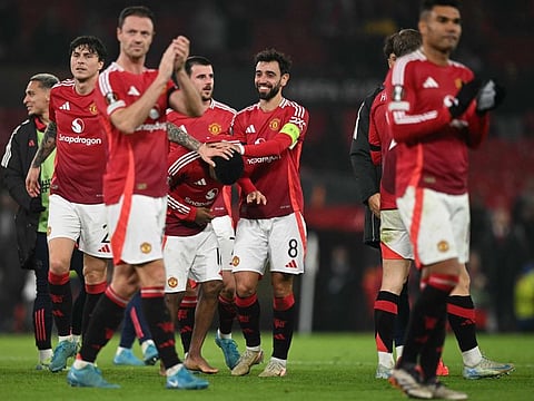 Manchester United's Portuguese midfielder Bruno Fernandes (centre) jokes with midfielder Amad Diallo after the Uefa Europa league, League Phase football match against PAOK Thessaloniki at Old Trafford stadium in Manchester, north west England, on November 7.
