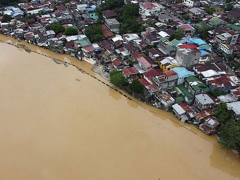 An aerial photo shows a swollen river inundating farm fields and houses in Ilagan town, Isabela province.