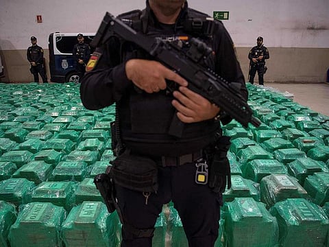 Spanish National Police and Customs officers stand next to packages of cocaine that were found in a container from Ecuador, during a police press conference at the port of Algeciras, southern Spain, on November 6, 2024.