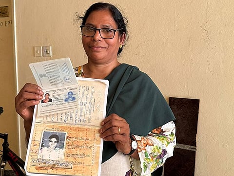 Gudala Baby shows her old and new travel documents in front of her shared accommodation in Dubai on Wednesday