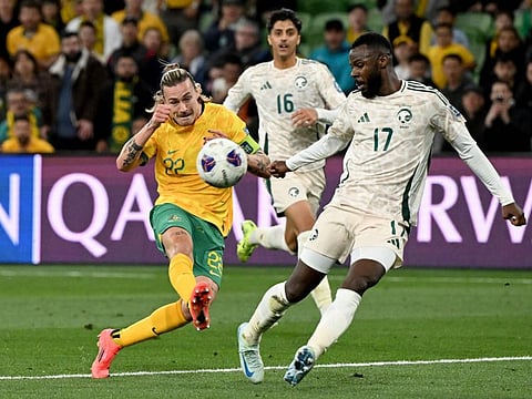 Australias Jackson Irvine (left) shoots for goal next to Saudi Arabias Hassan Al Tambakti during the 2026 World Cup Asian qualification football match at the Melbourne Rectangular Stadium in Melbourne on Thursday.