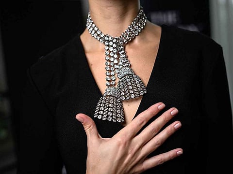 A woman wearing an 18th century diamond jewel necklace composed of three rows of diamonds finished with a diamond tassel at each, weighing approximately 300 carats, poses during a press preview at Sotheby's auction house in Geneva.