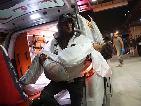 A paramedic carries a wounded Palestinian boy into the Nasser hospital in Khan Yunis following Israeli strikes in the southern Gaza Strip.