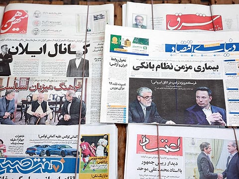 A picture taken at a news stand in Tehran on November 16, 2024 shows copies of Iran's Donyaye Eqtesad (C-R), Ham Mihan (top-L) and other daily newspapers with the main front-page headline highlighting the New York Times' report on a meeting between Tehran's ambassador to the United Nations Amir Saeid Iravani and tech billionaire Elon Musk earlier this week.