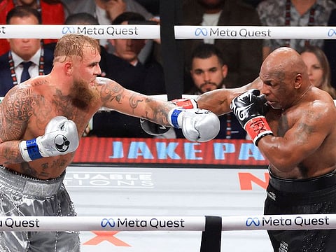 Jake Paul (L) and Mike Tyson throw punches during their heavyweight bout at AT&T Stadium in Arlington, Texas.