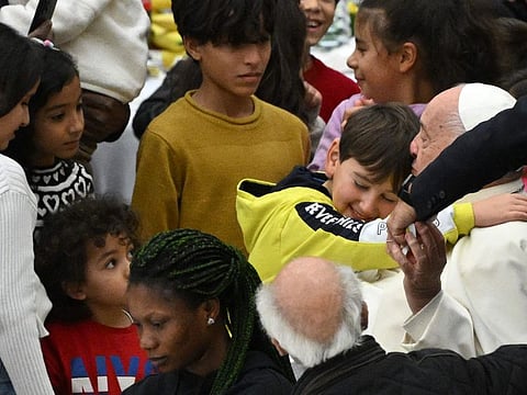 Children gather around Pope Francis as he arrives to attend a lunch organised on the World Day of the Poor at the Paul VI audience hall in The Vatican, on November 17, 2024.
