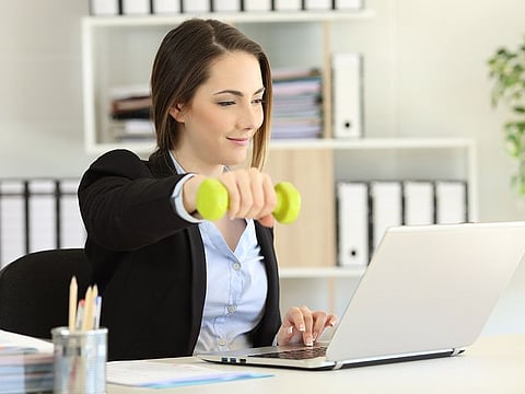 Keep a stretch band or a pair of light weights in your desk drawer for a quick strength boost