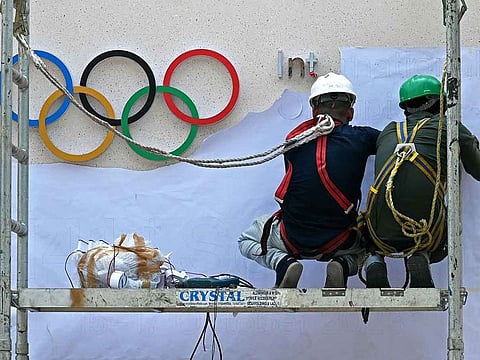 File picture: Labourers work beside the Olympic signage at the entrance of a venue of the 141st International Olympic Committee (IOC) session in Mumbai, India.