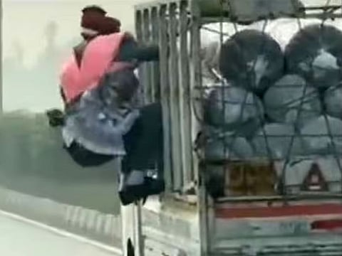The groom climbs aboard the mini truck to retrieve his cash garland from the thief who fled in the vehicle,