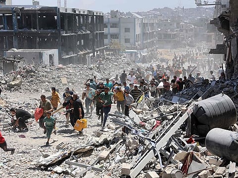 Palestinians who returned briefly to the Jabalia refugee camp in the northern Gaza Strip to check on their homes, run for cover after a school was hit by an Israeli strike.