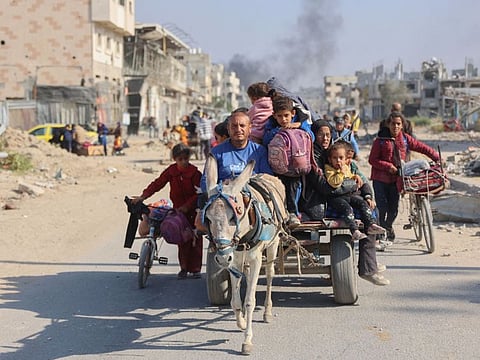 Palestinians displaced from shelters in Beit Hanoun cross the main Salaheddine road into Jabalia in the northern Gaza Strip on bicycles and donkey carts following Israeli army evacuation orders.