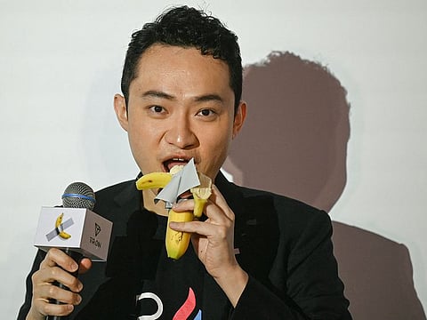 Chinese-born crypto founder Justin Sun eats a banana artwork composed of a fresh banana stuck to a wall with duct tape, in Hong Kong on November 29, 2024, after buying the provocative work of conceptual art by Italian artist Maurizio Cattelan at a New York auction for $6.2 million.