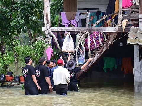 Volunteers distribute food supplies to flood-affected residents at Mueang district in Thailand's southern province of Narathiwat.