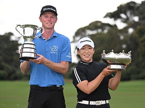 Ryggs Johnston of the US (left) and South Korea's Shin Ji-yai pose with their winner's trophies after the final round of the 2024 ISPS Handa Australian Open Golf tournament at the Kingston Heath Golf Club in Melbourne on Sunday.