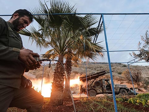 A militant remotely fires rockets against government forces, in the northern outskirts of Syria's west-central city of Hama on December 4, 2024.