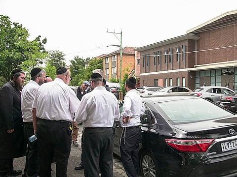 Members of the Jewish community gather near the scene of a fire at the Adass Israel Synagogue in Melbourne on December 6, 2024.