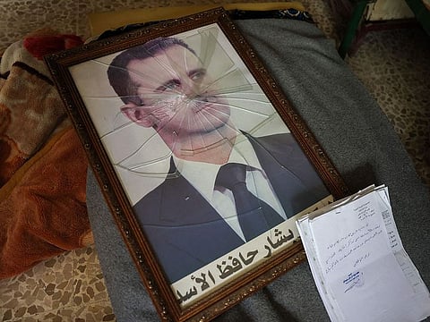 A portrait of Syrian President Bashar Al Assad is pictured with its frame broken, in a Syrian regime's Political Security Branch facility on the outskirts of the central city of Hama