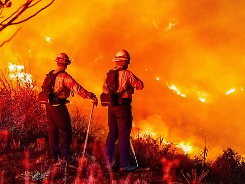 Firefighters monitor a burning hillside around Pepperdine University during the Franklin fire in Malibu, California, on December 10, 2024.