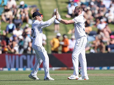 England’s Gus Atkinson (R) and Jacob Bethell (L) celebrates the wicket of New Zealand’s Daryl Mitchell on day one of the third Test cricket match between New Zealand and England at Seddon Park in Hamilton on December 14, 2024