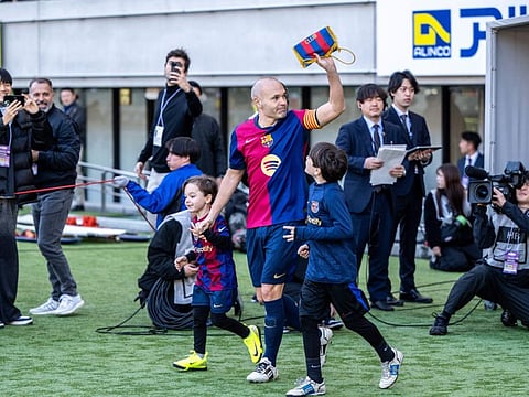 Retiring Spanish football legend Andres Iniesta walks to the pitch before the exhibition football match between former Barcelona and Real Madrid players -- Barca Legends and Real Madrid Leyendas -- at Ajinomoto Stadium in Tokyo on Sunday.