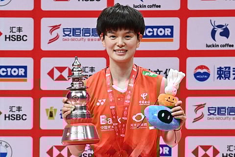 China's Wang Zhiyi celebrates with the trophy after winning the women's singles final against Han Yue at the BWF Badminton World Tour Finals in Hangzhou on SUnday.