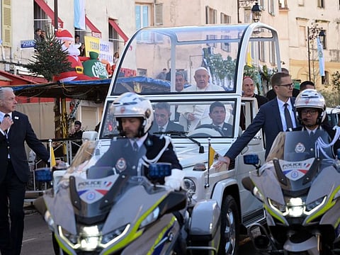 Pope Francis in the popemobile under police escort to pay his respects to the small statue of the Madonuccia (Ajaccio's patron saint) in Ajaccio, as part of his trip on the French island of Corsica, on December 15, 2024.