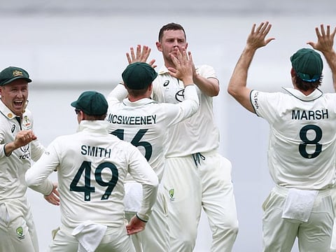 Australia's Josh Hazlewood celebrates the wicket of India's Virat Kohli with teammates on day three of the third Test match at The Gabba in Brisbane on Monday.
