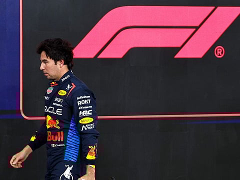 Red Bull Racing's Mexican driver Sergio Perez walks to his garage after the qualifying session ahead of the Abu Dhabi Formula One Grand Prix at the Yas Marina Circuit in Abu Dhabi on December 7.