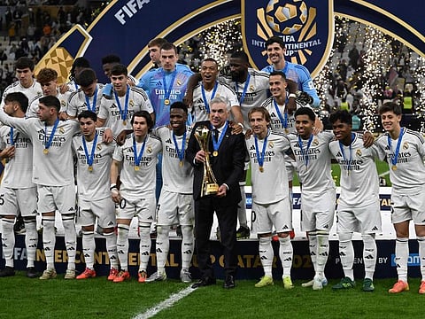 Real Madrid's Italian coach Carlo Ancelotti holds the tournament trophy as he poses with his players at the podium ceremony after the 2024 Fifa Intercontinental Cup final football match against Mexico's Pachuca at the Lusail Stadium in Doha on Wednesday.