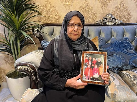 Najah Mardini, the mother of detained Syrian dentist and former national chess champion Rania Al Abassi, holds up a family picture of her daughter at her home in the Saudi capital Riyadh on December 12, 2024.