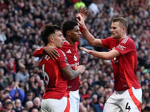 Manchester United's striker Marcus Rashford celebrates with defender Lisandro Martinez and defender Matthijs de Ligt after scoring the opening goal of the English Premier League football match against Everton at Old Trafford in Manchester on December 1.