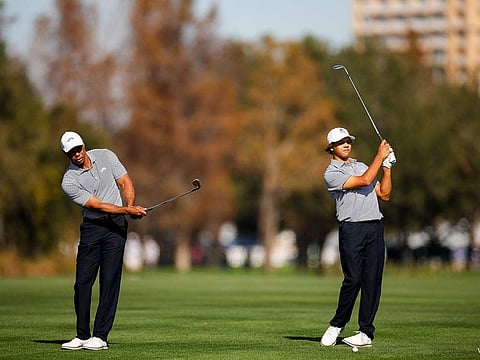 Tiger Woods and his son Charlie Woods wait to hit their approach shots on the 18th hole during the first round of the PNC Championship at Ritz-Carlton Golf Club on December 21, 2024 in Orlando, Florida.
