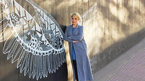 Kelsey Montague with her work in Buenos Aires. The artist has created over 125 murals all over the world