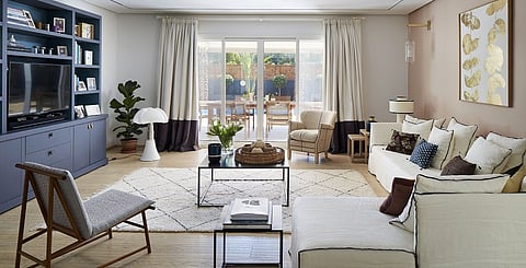 The inviting living room features soft blush tones, creamy whites and warm woods, while the striking black details add contrast and tie the different pieces together effectively