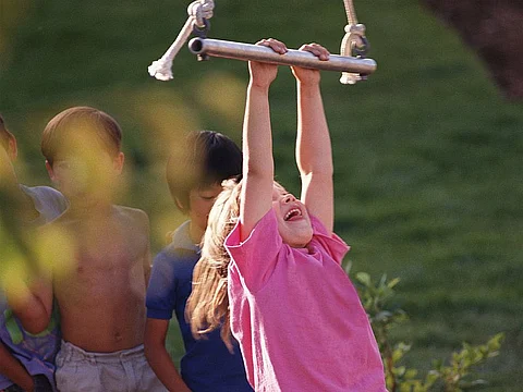 child hanging from swing
