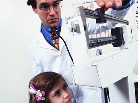 doctor checking the weight of a girl