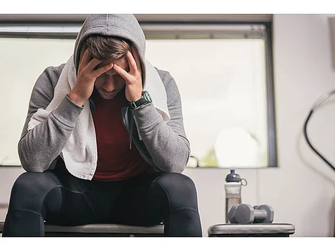 man looking depressed sitting in the gym