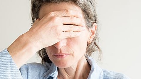 older woman holding her head