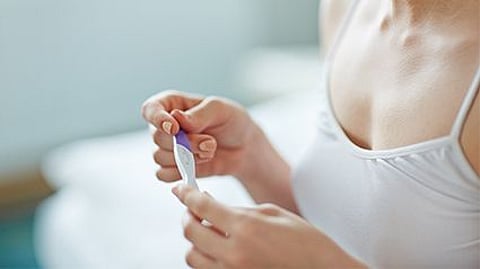 a woman looking at the pregnancy test