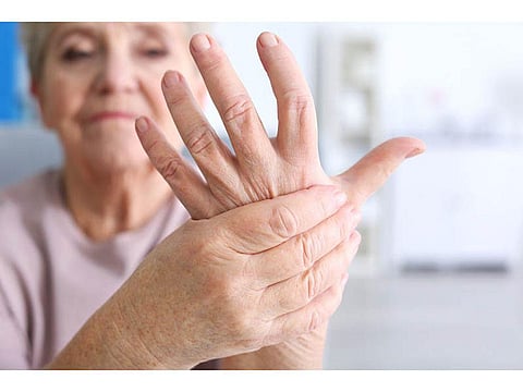 woman holding her hand in pain