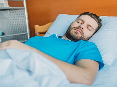 man sleeping in hospital bed