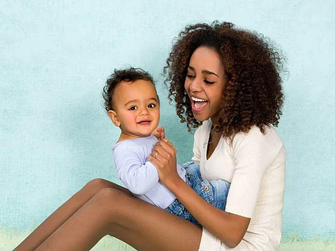 woman sitting and playing with a baby boy