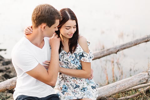 Young loving couple hugging near lake.
