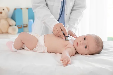 Doctor examining little baby with stethoscope in clinic. Baby health concept