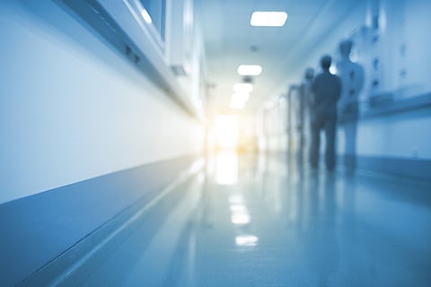 Doubled silhouette of medical worker in hospital hall, unfocused background