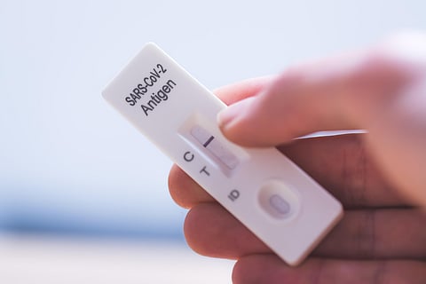close up of fingers holding a negative covid antigen test