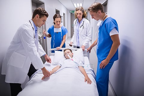 Doctors pushing emergency stretcher bed in corridor