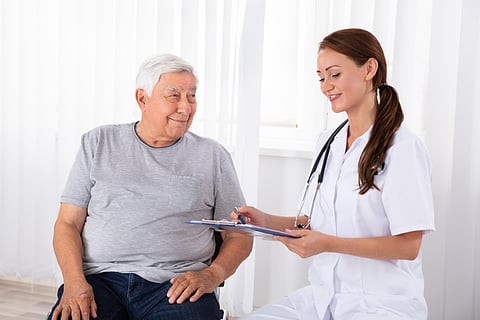 Doctor With Clipboard Giving Prescription To Male Patient