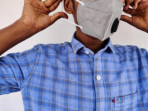 Young man wearing gray color KN-95 face mask. Blue shirt guy. Corona virus protection. Corona virus pandemic. Wear mask before you go out