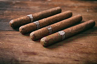 four cigars on wooden table